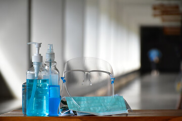 New normal, Hand sanitizer gel, faceshield and facemasks in front of the office for cleaning hands and wearing on face before getting inside to protect and prevent Coronavirus or Covid-19 and germs.