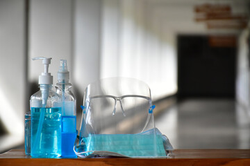 New normal, Hand sanitizer gel, faceshield and facemasks in front of the office for cleaning hands and wearing on face before getting inside to protect and prevent Coronavirus or Covid-19 and germs.