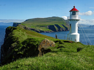 Fototapeta na wymiar The lighthouse on Mykines, Faroe Islands with a view on the island. 