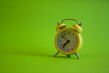 yellow alarm clock on a green background