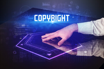 Hand touching digital table with COPYRIGHT inscription, new age security concept