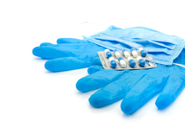 medical blue gloves, mask and pills in a blister pack on a white background.