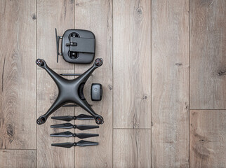 Dark drone on a wooden background. Unmanned aerial vehicle on the background of the boards.