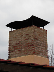 Red and Yellow House Chimney on Cloudy Winter Day with Vertical Green Trees with Shingles Nature Construction