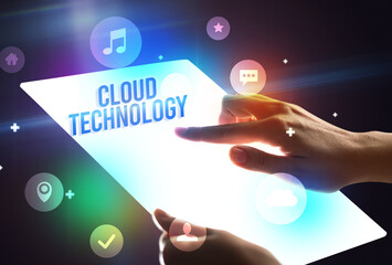 Holding futuristic tablet with CLOUD TECHNOLOGY inscription, new technology concept