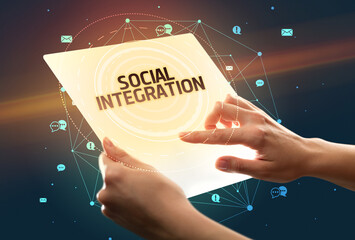 Holding futuristic tablet with SOCIAL INTEGRATION inscription, social media concept