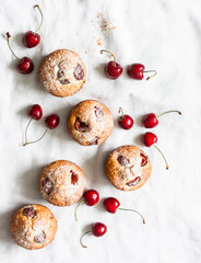 Homemade cherry muffins and fresh cherries on a light background. the view from the top. Delicious...