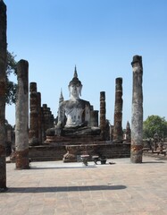 Fototapeta na wymiar Statue of Buddha in Sukothai Historical Park. Ancient city Sukothai is now famous tourist destination in Thailand.