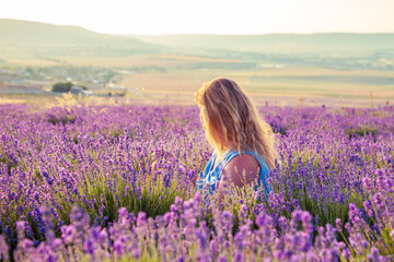 Girl in a lavender field at sunset. Sunny summer evening in Crimea.