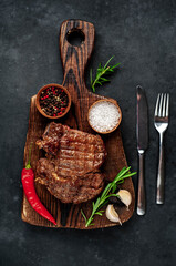 Obraz na płótnie Canvas Grilled beef steak with spices on a stone background