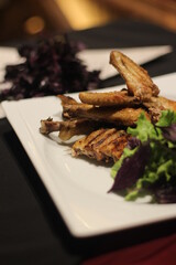 Chicken tabaka with greens on a color background.