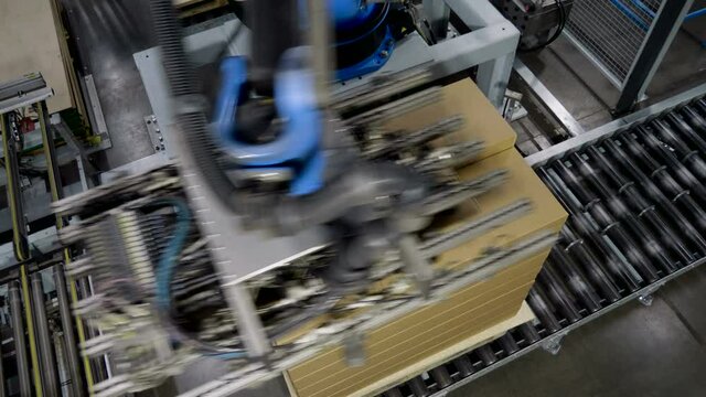 Furniture factory. A modern automated machine packaging furniture parts in cardboard boxes. 4K