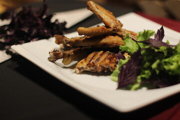 Chicken tabaka with greens on a color background.