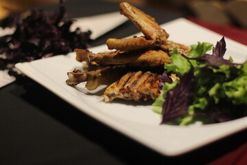 Chicken tabaka with greens on a color background.