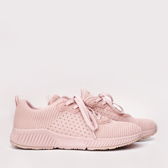 Pink female sneakers isolated on white background.