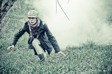 a girl sneaks on the grass from the dense smoke