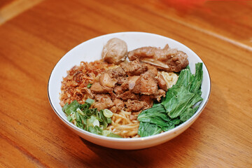 Chicken noodles with some beef meatballs. pieces of mustard leaf. rib meat