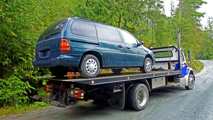 Towing service - the blue tow truck with the loaded old damaged car which stopped working in the...