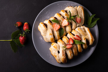 Chocolate puff pastry. Home baked dark chocolate sweet pie on black background with copy space