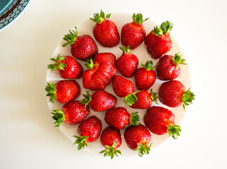 Delicious juicy strawberries on a white plate. Fresh strawberries.