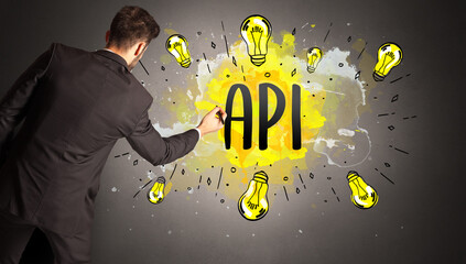 businessman drawing colorful light bulb with API abbreviation, new technology idea concept
