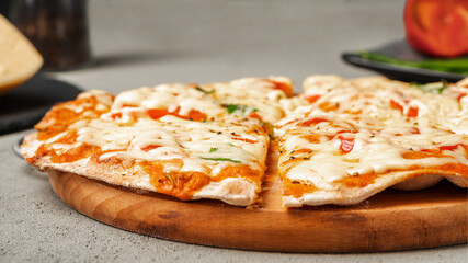 Vegetarian pizza on a wooden Board on a concrete background near the ingredients. Close up