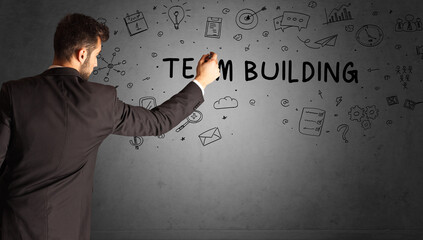 businessman drawing a creative idea sketch with TEAM BUILDING inscription, business strategy concept