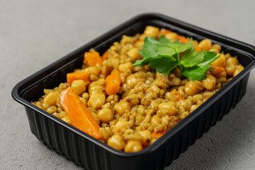 Vegetarian pilaf in a biodegradable shipping container is decorated with greenery