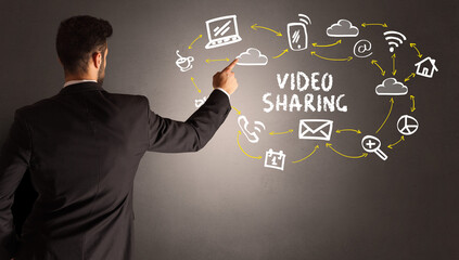 businessman drawing social media icons with VIDEO SHARING inscription, new media concept