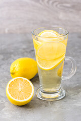 Refreshing lemon drink in a glass on the table. Alternative medicine.