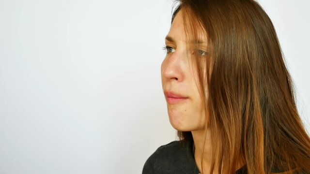 A pretty girl puts two chewing gum pads in her mouth and chews them