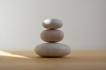 Stone cairn on striped grey white background, three stones tower, simple poise stones, simplicity harmony and balance,