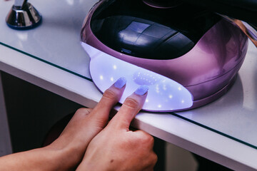 ultraviolet lamp, the girl dries fresh nails