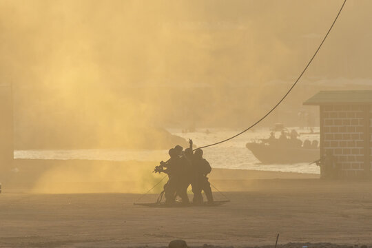 Military Combat helicopter rescue team on the ground with a rope in the smoke and haze.