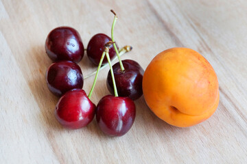 apricot and some cherries on a wooden tray