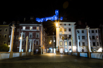 Fototapeta na wymiar Ljubljana city at night. Capitol of Slovenia in December. Blue colors on castle walls. View of Cobblers bridge. Long exposure, wide shot, low angle