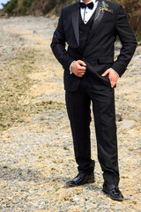 Groom in wedding tuxedo waiting for bride on the beach. Elegant caucasian groom without face. 