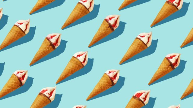 Beautiful background from  of large group of  ice cream. 
Appetizing ice cream cones rotating on light blue background.
Flat lay, top view. Isometric view. Seamless loop video. 