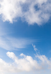 Beautiful vertical blue sky with mix of white clouds