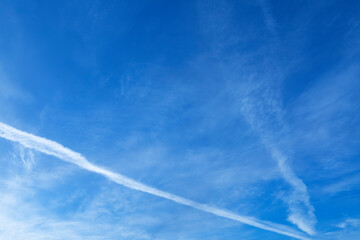 Fototapeta na wymiar Blue sky with airline crossing it on left side