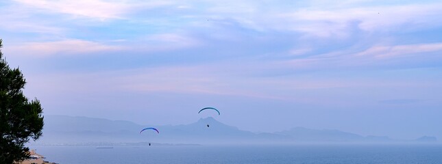 Windsurfer on the beach with a cloudy sky