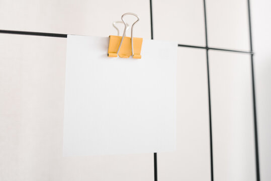 note paper and yellow paper clip on a light background and a mudboard