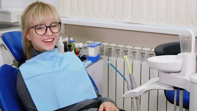 Female patient waiting for dentist doctor in stomatology chair. Healthcare, teeth cleaning and caries prophylaxis concept.