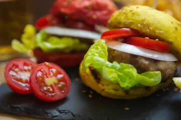 Burgers of colored breads on a black slate board