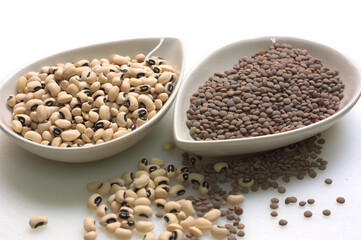 Close-up of two bowls with black beans and lentils sowhite background