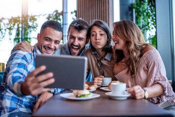 Cheerful friends resting in the cafe
