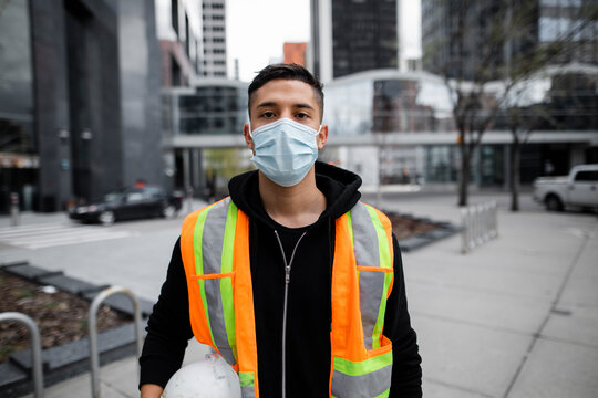 Portrait confident male construction worker in face mask in city