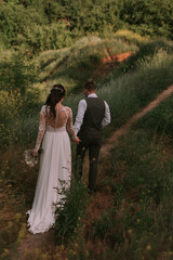 Bride and groom walking through the park