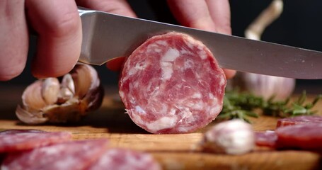 Slices of salami with slices of garlic and rosemary.