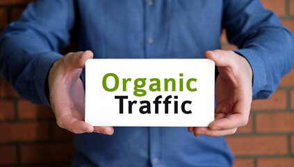 Organic seo traffic - concept in the hands of a young man in a blue shirt